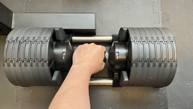 手でFLEXBELLのダイヤル部分を握り、重量変更する瞬間の様子